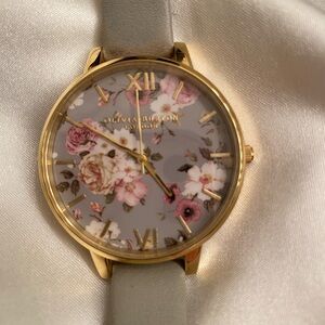 Women’s Olivia Burton grey and floral watch with leather band.